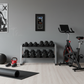 A well-equipped home gym with various fitness equipment, including dumbbells, a stationary bike, and a yoga mat.