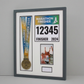 a framed display with a gold medal, a photo of a runner, and a number pinned to it, indicating the runner's finish time and place in the marathon.